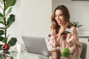 Hausfrauenkredit Lachende Frau am Laptop